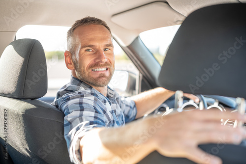 Attractive man driving a car on a clear day. Buying or renting a car. © Denis Rozhnovsky