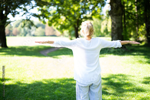 Frau im mittleren Alter macht Übungen im Park, Yoga und Meditation 