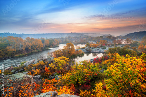 piękny krajobraz jesień z kolorowymi drzewami i mglistą rzeką o zachodzie słońca