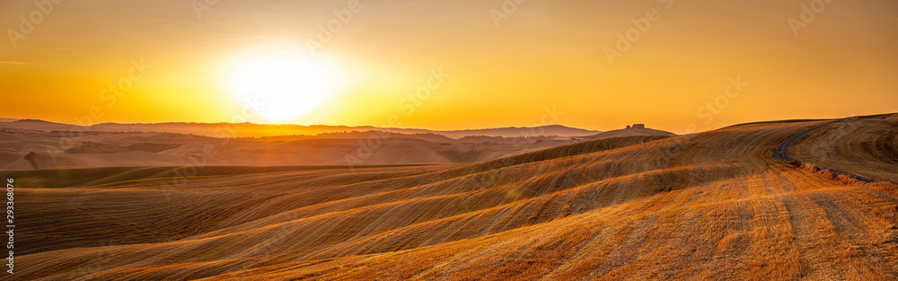 Beautiful Tuscany panorama of Crete Senesi golden sunrise with farm house and rolling hills