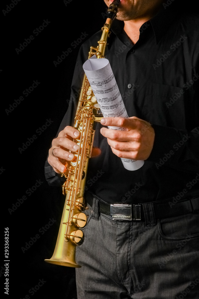Fototapeta premium soprano saxophone in hands on a black background