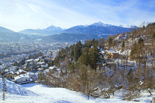 Tyrol winter panorama in Innsbruck, Austria. Houses covered with snow and Alps mountains at the background. 