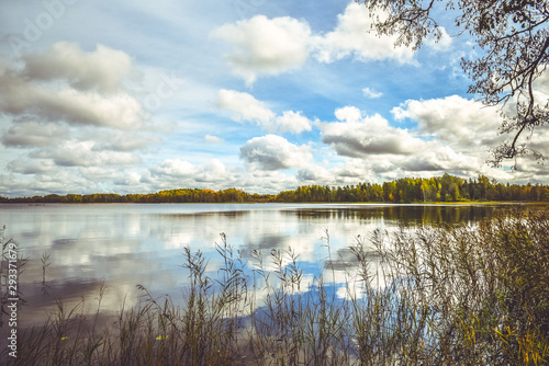 Reflection of blue sky and white clouds in the water of a small lake