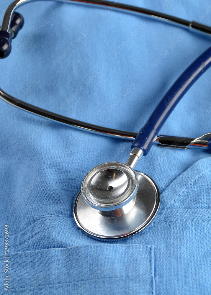 Medical stethoscope head on a blue doctor uniform in a hospital office. Conceptual photo. Selective focus. Medical stethoscope head on a blue doctor uniform in a hospital office. Conceptual photo. Selective focus.