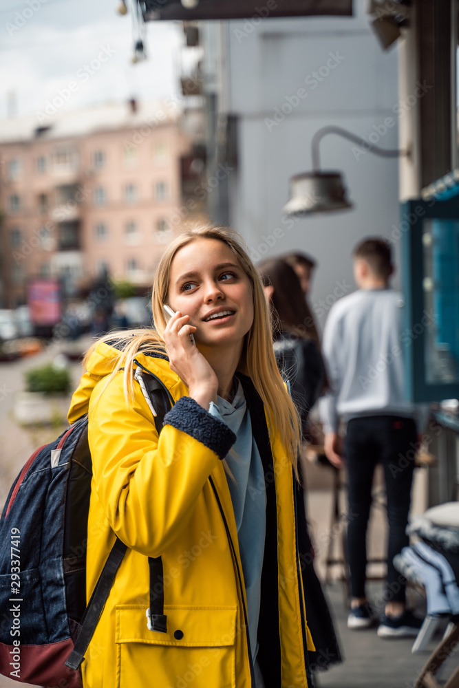Fototapeta premium Woman walking and using a smartphone in the street