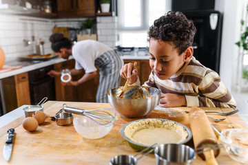 Son is helping mother to prepare pumpkin pie. American family. Single mother. Household chores for kids.