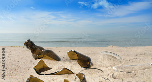 Pollution from broken glass bottles lying on a beach