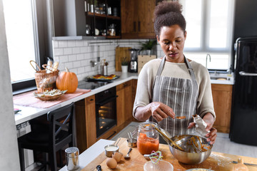 African american woman preparing pumpkin pie for holidays