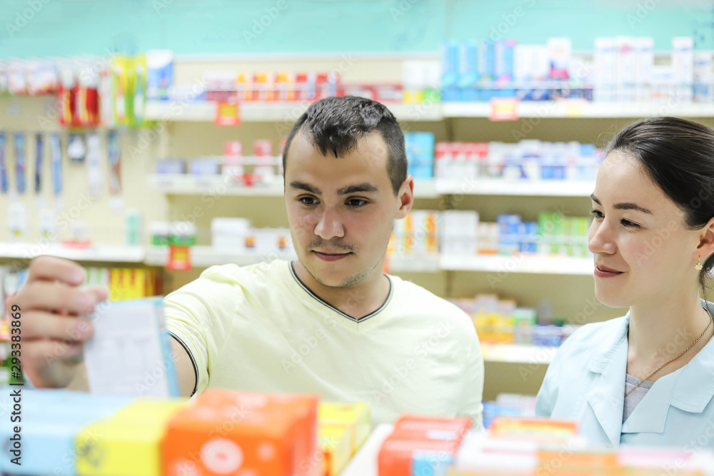 A female pharmacist advises the client on the choice of drugs. A man buys pills at the pharmacy. A female pharmacist advises the client on the choice of drugs. A man buys pills at the pharmacy.