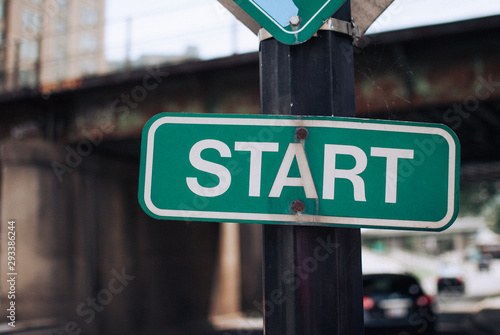 Start sign on pole in city with blurred bridge in background Washington, DC