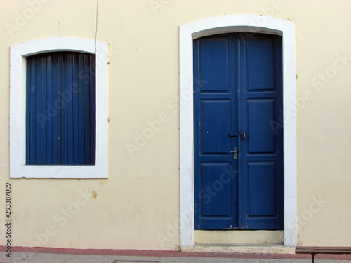 Yellow wall and blue wooden doors of building in the Sobral center