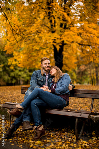 Young loving couple on a bench in autumn park