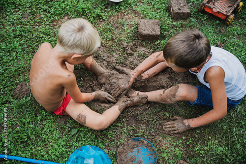 Two brothers playing with mud photo