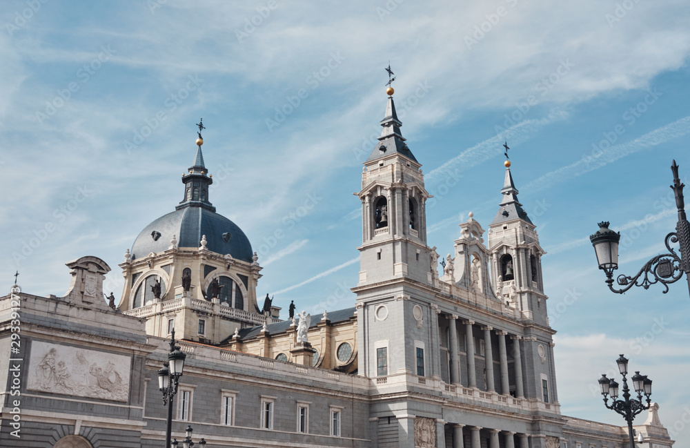 view of the Cathedral of Santa Maria la Real de la Almudena in a sunny day with clead blue sky and clouds.