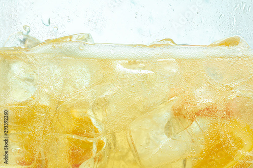 Fotografiet Close up of lemon slices in stirring the lemonade and ice cubes on background