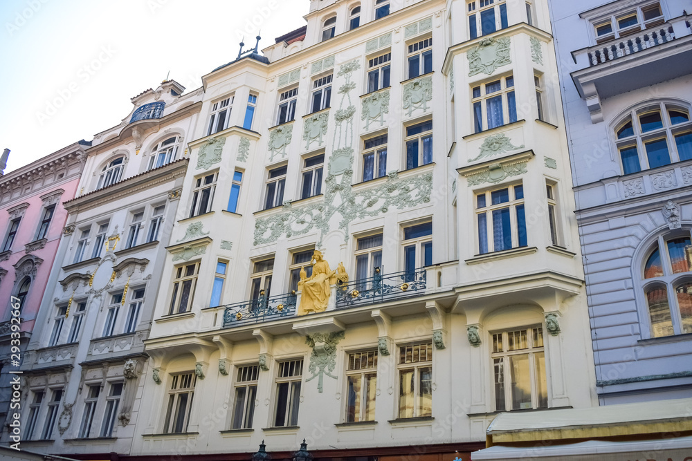 Facade of an old beautiful building with an ornament and a golden sculpture in Prague