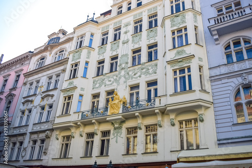 Facade of an old beautiful building with an ornament and a golden sculpture in Prague