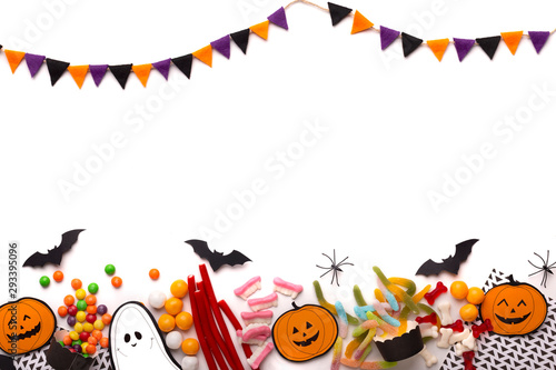 Happy Halloween candies with paper decorations and copy space