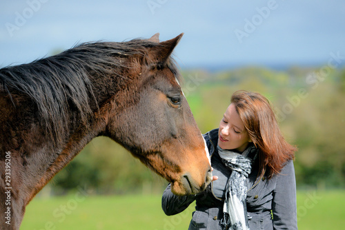 clsoe up shot of pretty young woman and her beautiful bay horse sharing a loving moment in the field. © Eileen