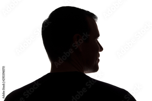 Portrait of a young man, back view - dark isolated silhouette