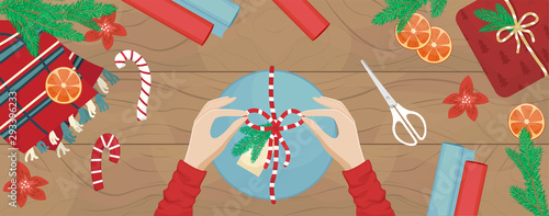 Girl packs a Christmas gift and ties a bow. Flat vector Christmas illustration.