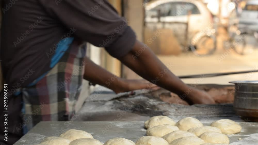 A man putting handmade chapati/ roti/naan bread in Tandoor, a cylindrical clay or metal oven used in cooking and baking in Northern India. It's used for cooking in Southern, Central and Western Asia A man putting handmade chapati/ roti/naan bread in Tandoor, a cylindrical clay or metal oven used in cooking and baking in Northern India. It's used for cooking in Southern, Central and Western Asia