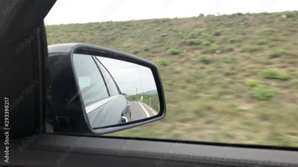 Close-up view of side mirror from vehicle on motorway. Driving a car along field. View from car window. Car side mirror view. Highway travel. Slow motion video. Close-up view of side mirror from vehicle on motorway. Driving a car along field. View from car window. Car side mirror view. Highway travel. Slow motion video.