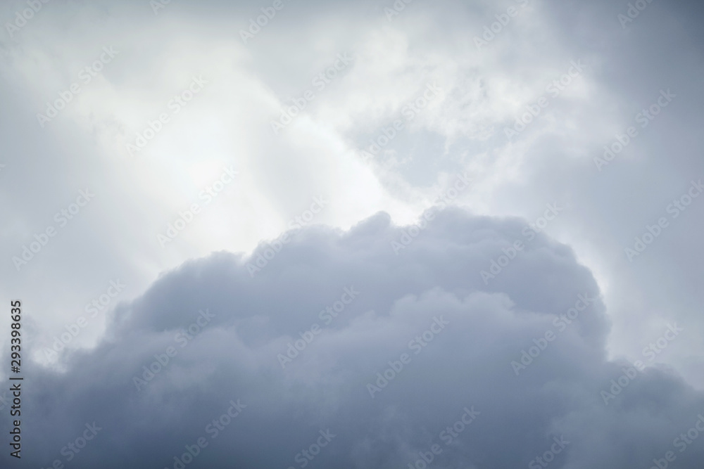 Dark storm clouds below at light sky background