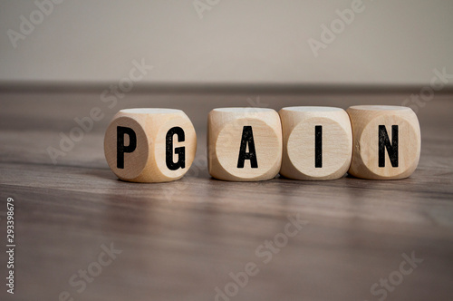 Cubes and dice with two words Pain and Gain on wooden background © Stockwerk-Fotodesign