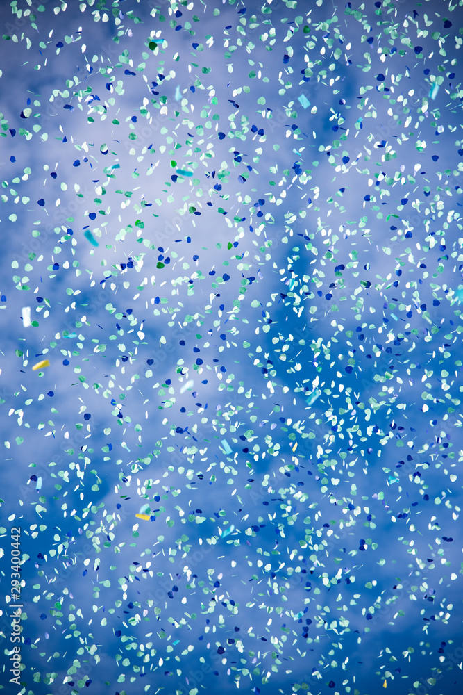 Cloud of confetti with blue sky background. For carnival, parties, birthdays and Valentine's Day.