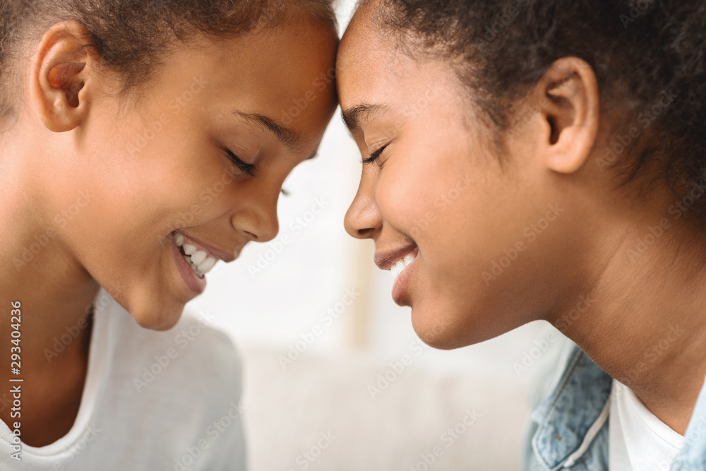 Two sisters with eyes closed touching each other with foreheads Two sisters with eyes closed touching each other with foreheads
