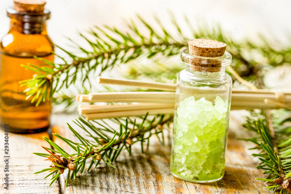 spa with organic spruce oil and sea salt in glass bottles on wooden table background spa with organic spruce oil and sea salt in glass bottles on wooden table background