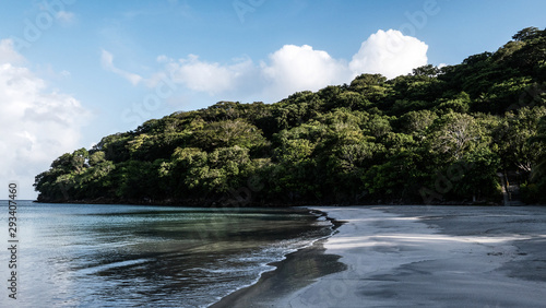 Beach with calm sea in green colors and mountain with tropical dry forest, on the island of Providencia, in the Colombian Caribbean