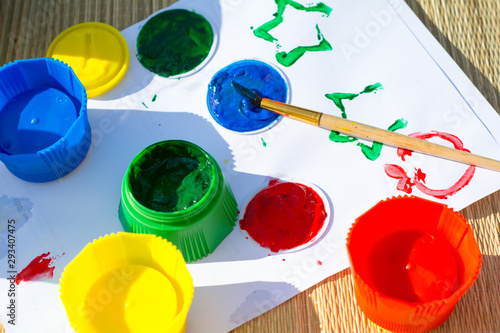 Cans of paint are on a painted sheet of white paper