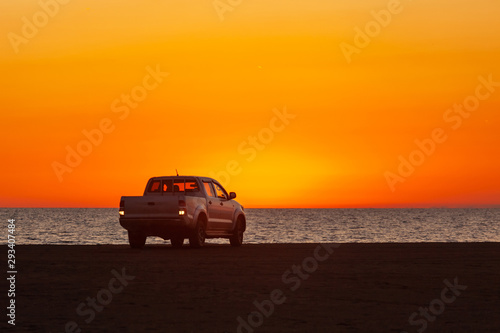 Pick-up truck parked in front of Black Sea at beautiful sunset.