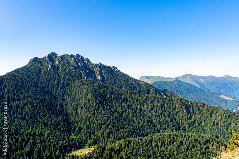 Slovakia national parkland Mala Fatra - view from Maly Rozsutec mountain to nearby hills and valleys. Sunny summer day, tourism and hiking in fresh and pure nature. Forest and green trees.