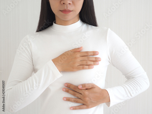 Картината върху платно breast cancer and breast pain in asian woman and she use hand touching her breast and symptom of change size or shape of one or both breasts use for medicine product or health care concept