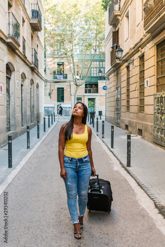 Young tourist girl is walking on the street in an european city searching for accommodation photo