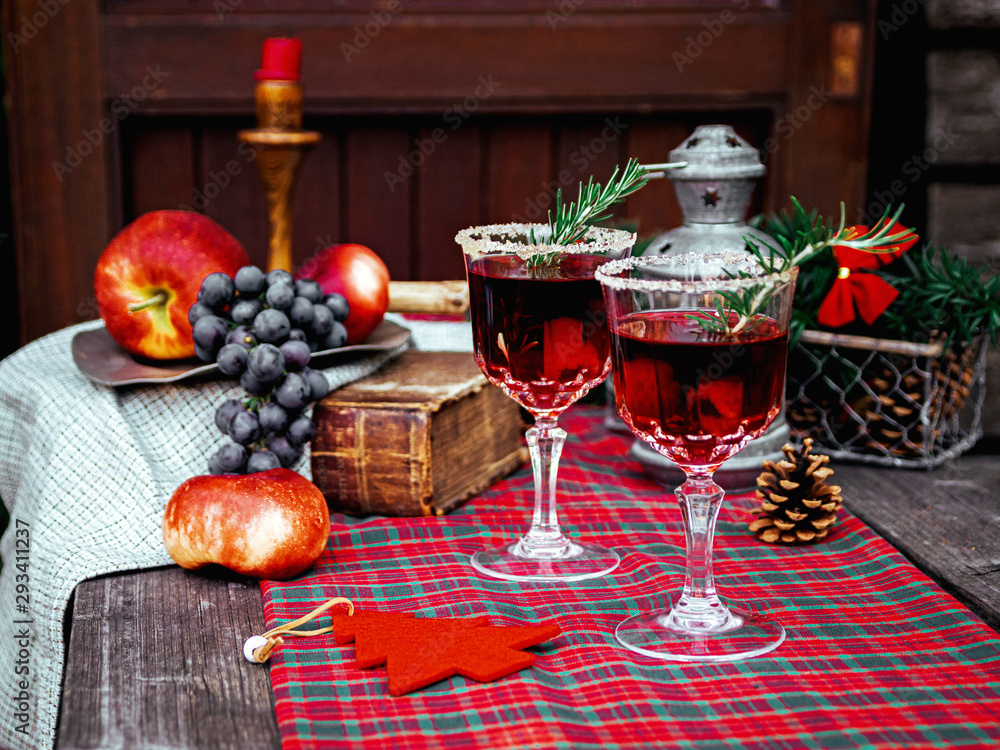 Christmas still life , two glass with red raspberry beverage decorated with rosemary , vintage old fashion style.