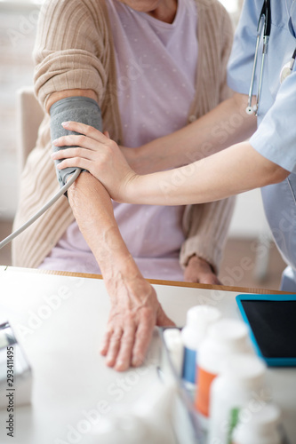 Medical worker measuring blood pressure for woman