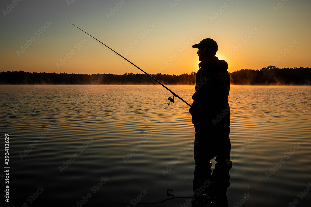 Male fisherman at dawn on the lake catches a fishing rod. Fishing hobby vacation concept. Copy space. Male fisherman at dawn on the lake catches a fishing rod. Fishing hobby vacation concept. Copy space.