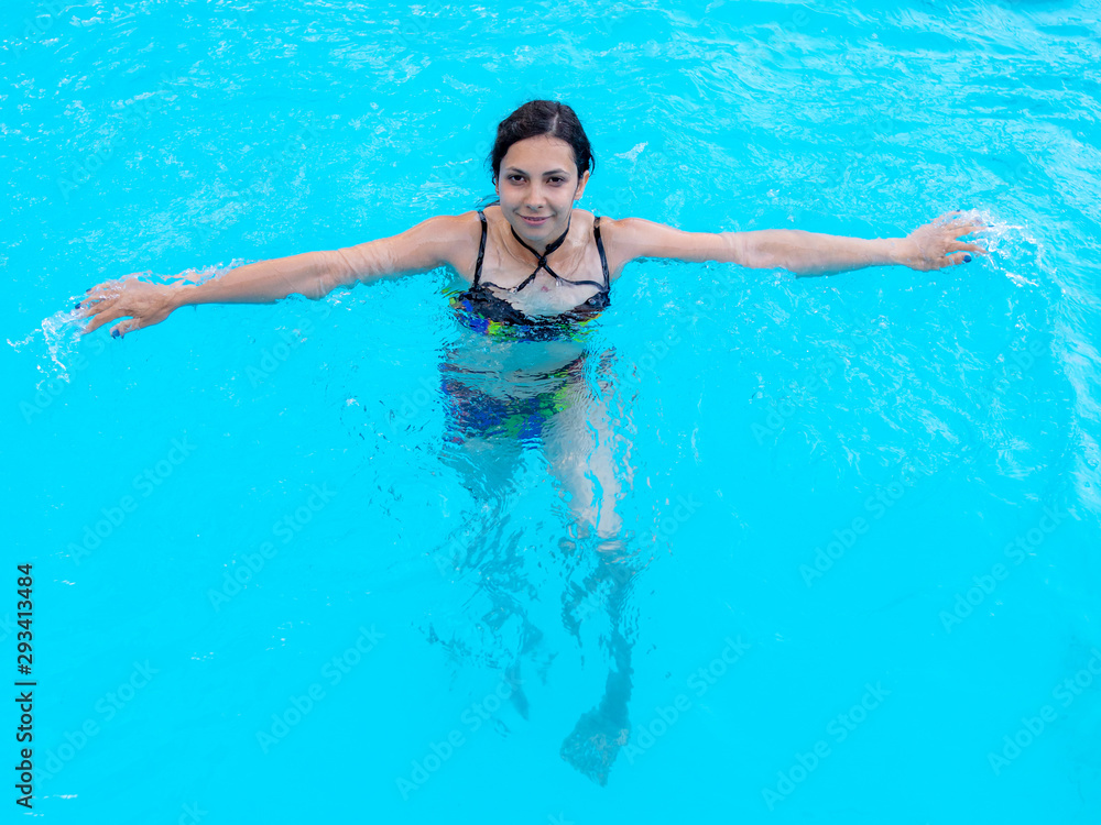Girl bathes in the blue pool water