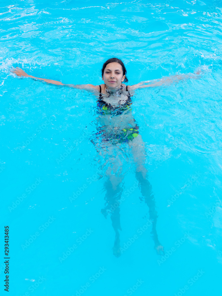 Girl bathes in the blue pool water