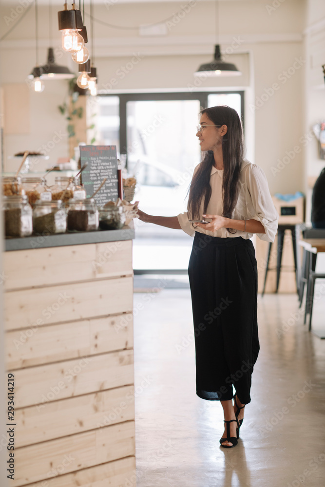 Young woman standing at the counter in a cafe Young woman standing at the counter in a cafe