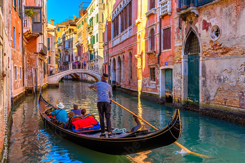Narrow canal with gondola and bridge in Venice, Italy. Architecture and landmark of Venice. Cozy cityscape of Venice. #293414266