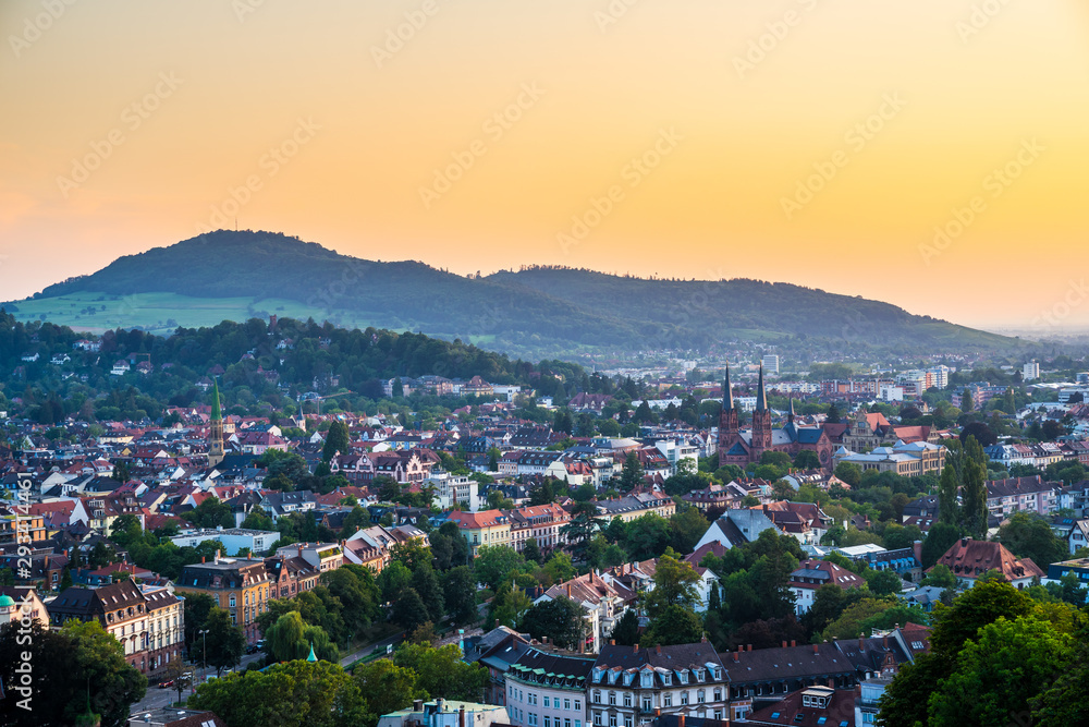 Germany, Aerial view over black forest city freiburg im breisgau from above at sunset in romantic orange dawning twilight mood