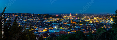 Germany, XXL panorama of illuminated stuttgart city skyline aerial view from above by night after sunset in magical twilight mood