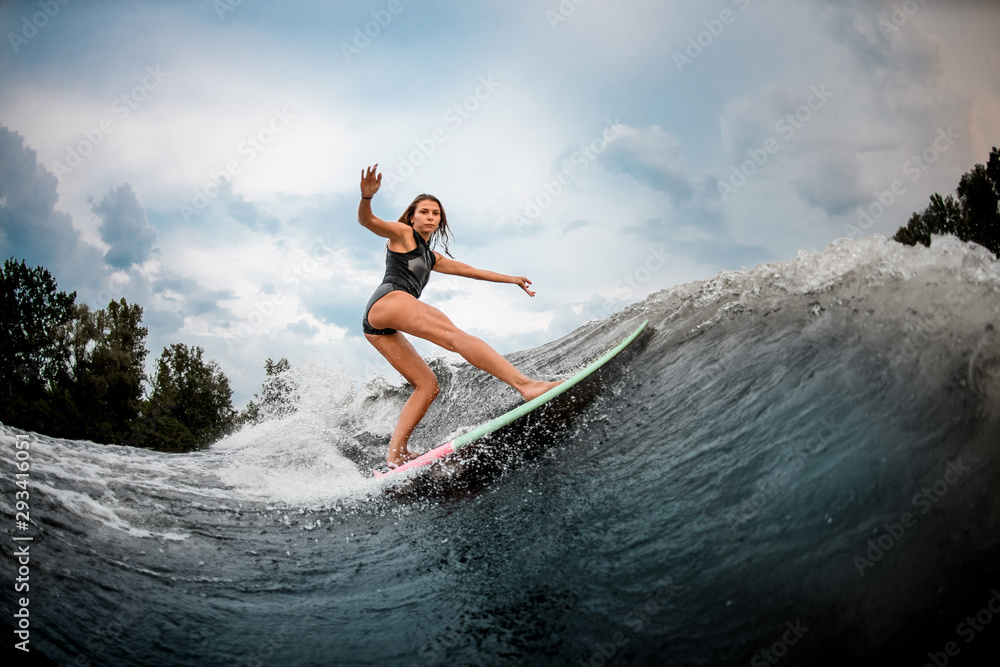 Girl wakesurfer performs stunts on a board