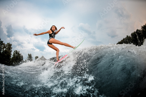 Girl wakesurfer makes stunts on a board