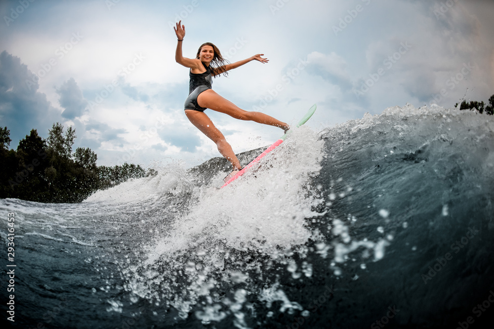 Girl wakesurfer making stunts on a board